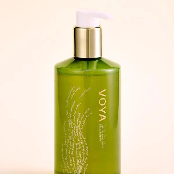 Green bottle with gold cap labeled 'VOYA' on a beige background