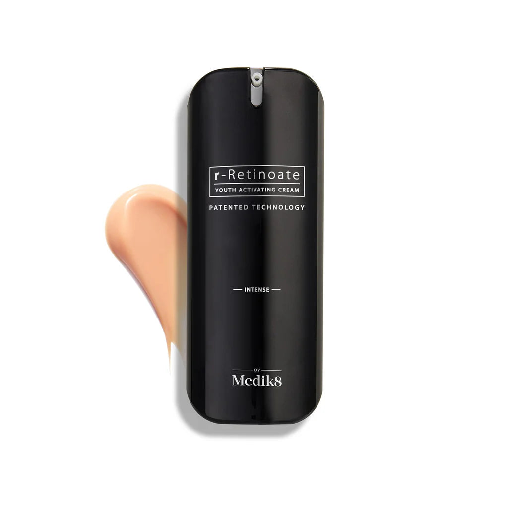 Black container of r-Retinoate cream by Medik8 with a swatch of beige color on a white background