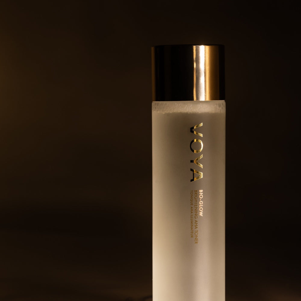Skincare bottle with gold cap on a dark background