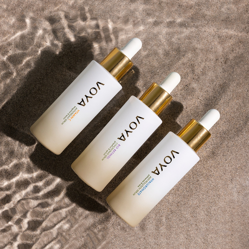 Three Voya skincare droppers on a textured brown surface