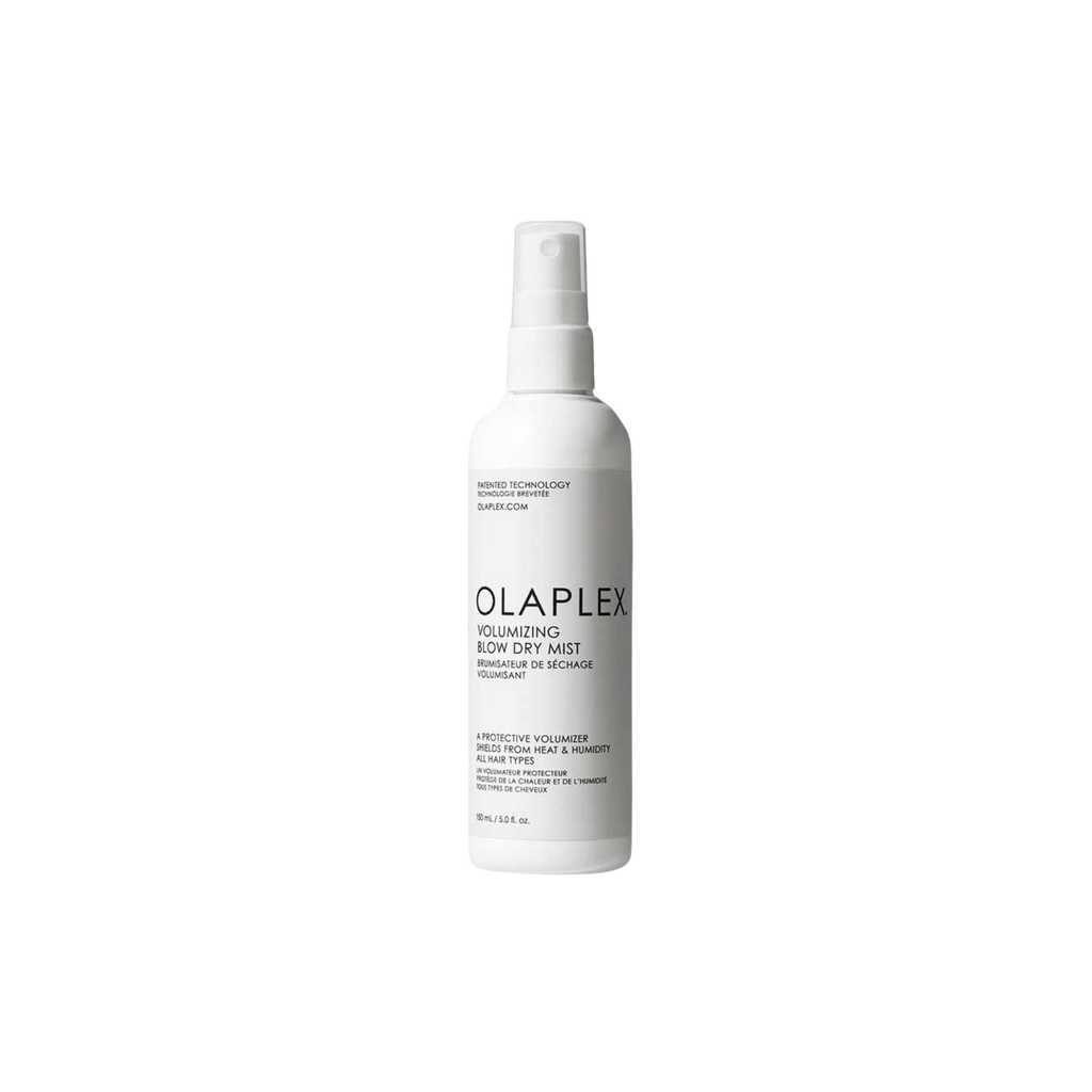A white spray bottle labeled Olaplex Volumising Blow Dry Mist, with product information and branding visible.