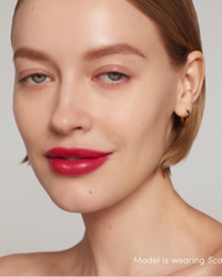 Close-up of a model wearing Jane Iredale Colorluxe lipstick in 'scarlet' with a neutral background