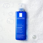 La Roche-Posay Toleriane cleanser bottle on a textured white background with bubbles.