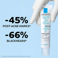 La Roche-Posay Effaclar Duo+M tube with gloved hand on light blue background