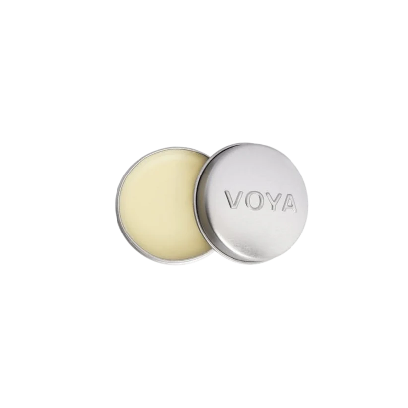 A round tin container of VOYA Lemon & Lime Organic Lip Balm, lid off, showing the balm inside.