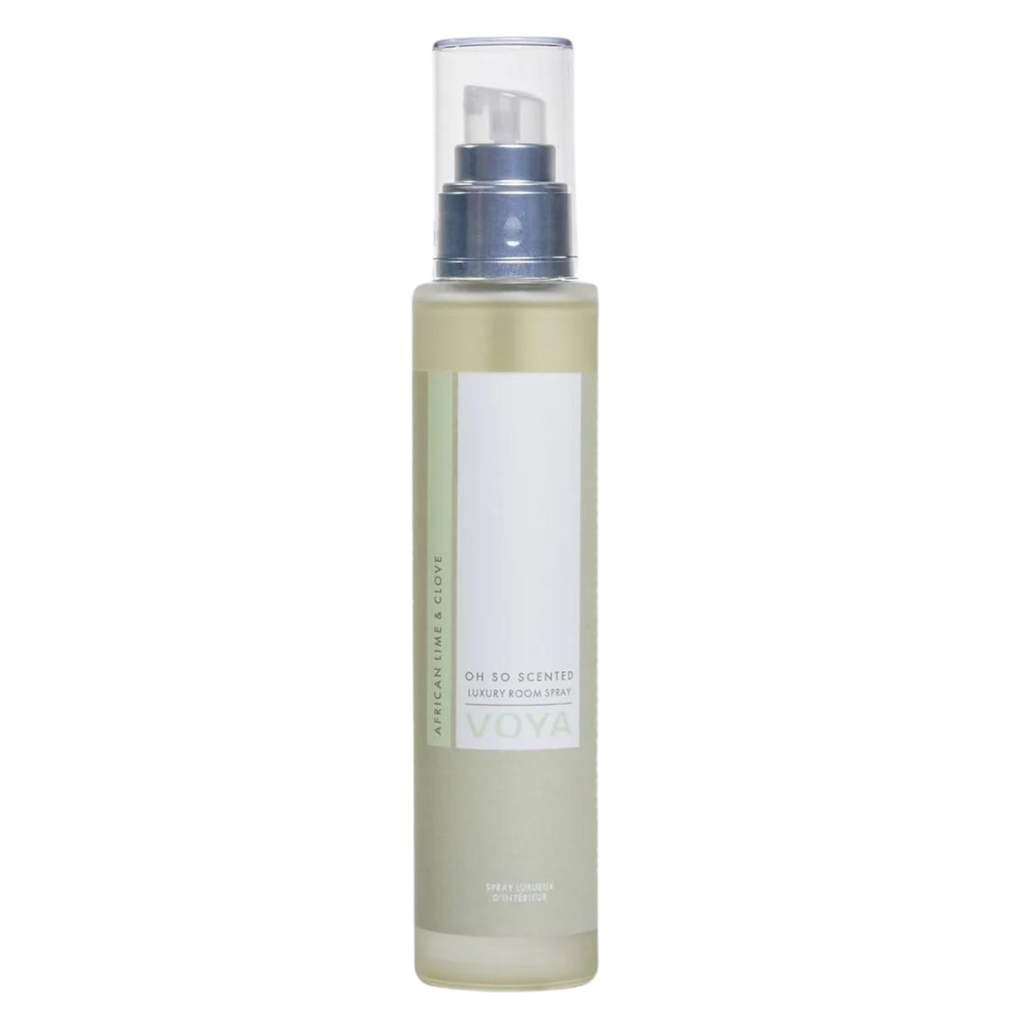 A clear bottle of Voya Oh So Scented Luxury Room Spray with a white label and spray nozzle, filled with a yellow liquid.