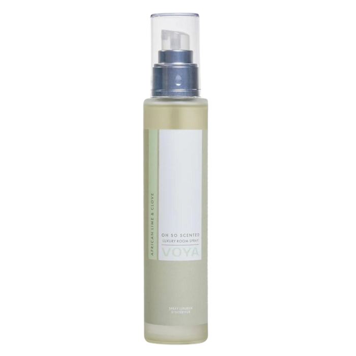 A clear bottle of Voya Oh So Scented Luxury Room Spray with a white label and spray nozzle, filled with a yellow liquid.
