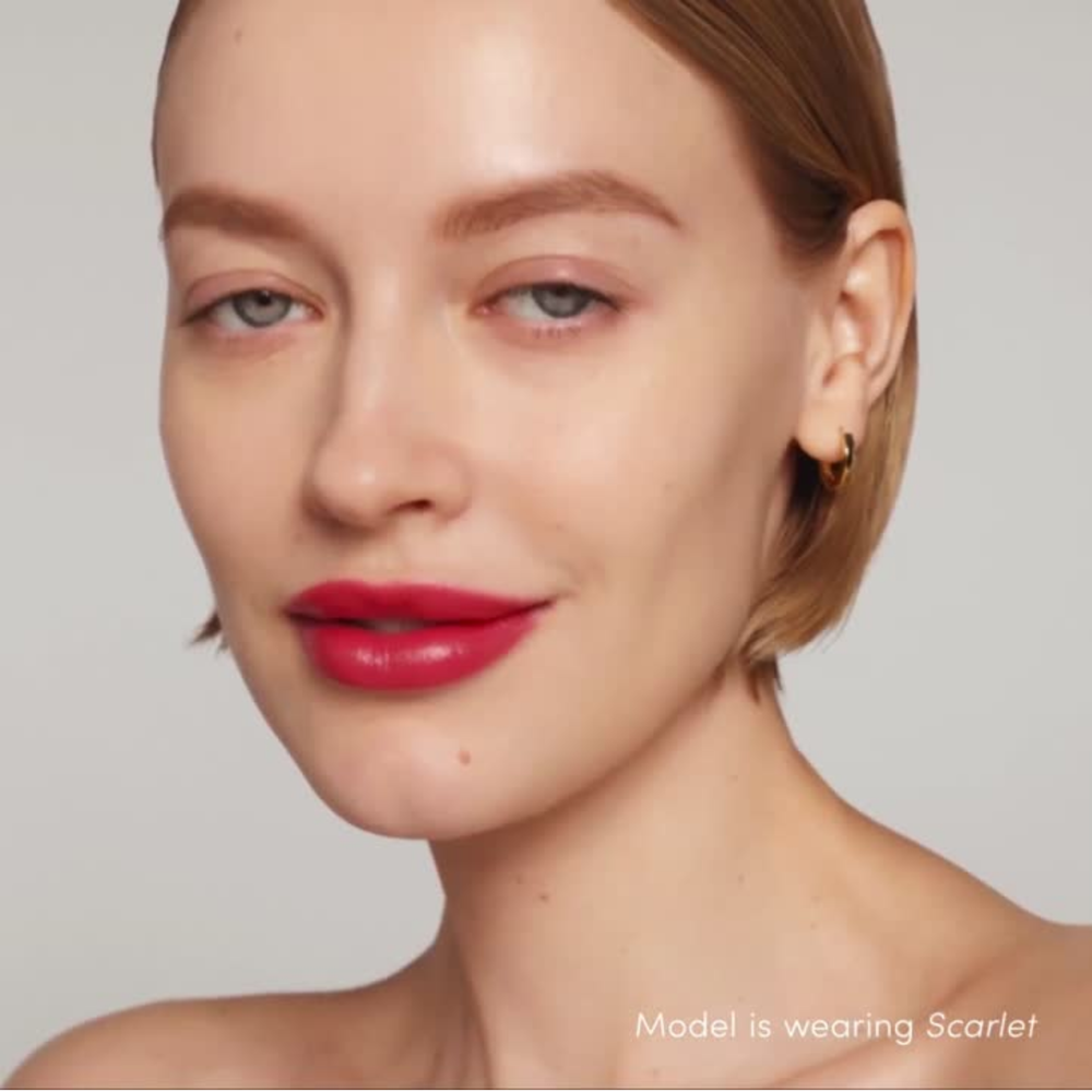 Close-up of a model wearing Jane Iredale Colorluxe lipstick in 'scarlet' with a neutral background