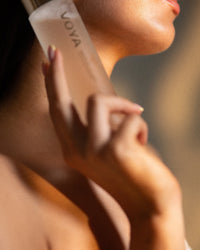 Person holding a Voya Bio-Glow skincare product with a blurred background