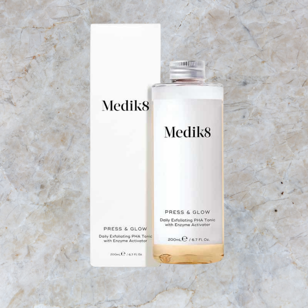 Clinically proven to deliver glowing skin in just 2 weeks, Medik8 press and glow, clear bottle with metal screw cap, white box packaging, 
removes dead surface skin cells, reveals smoother skin texture, create a visibly perfected skin surface, absorbs vitamin C and A, creates a smoother base for makeup.