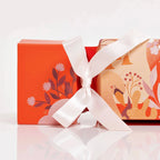 VOYA Gift cracker with floral design and white ribbon on a white background