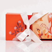 VOYA Gift cracker with floral design and white ribbon on a white background