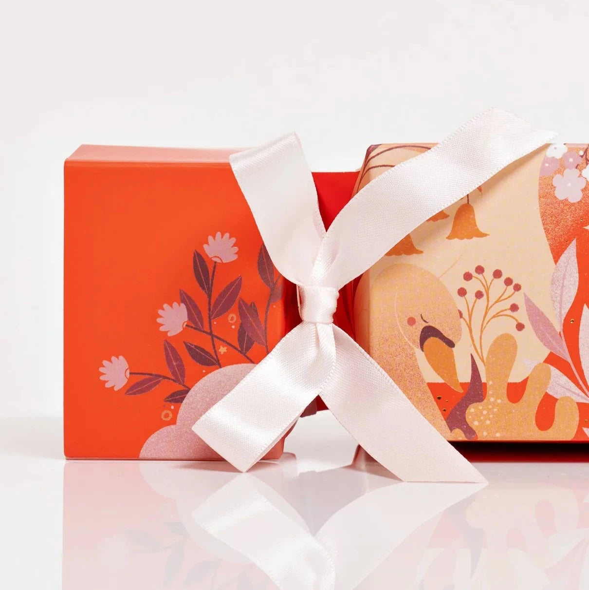 VOYA Gift cracker with floral design and white ribbon on a white background