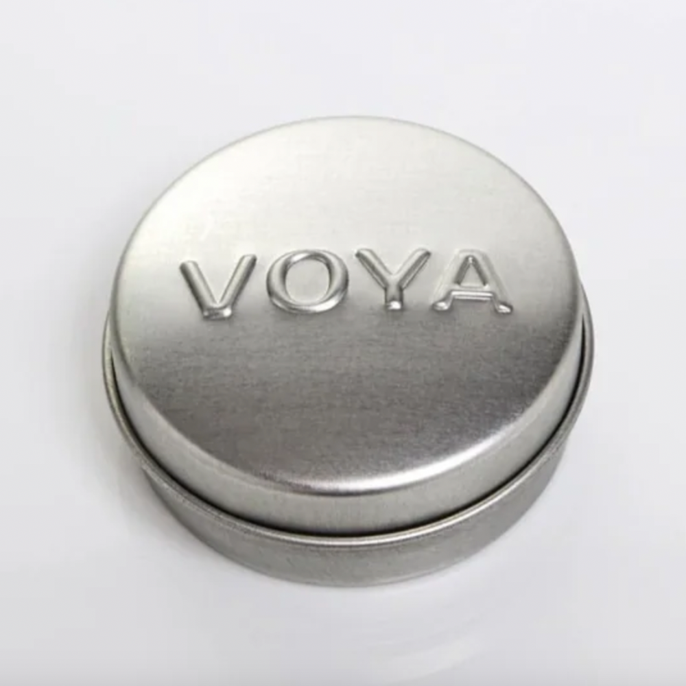 Silver cylindrical Balmelicious container with 'VOYA' branding on a white background