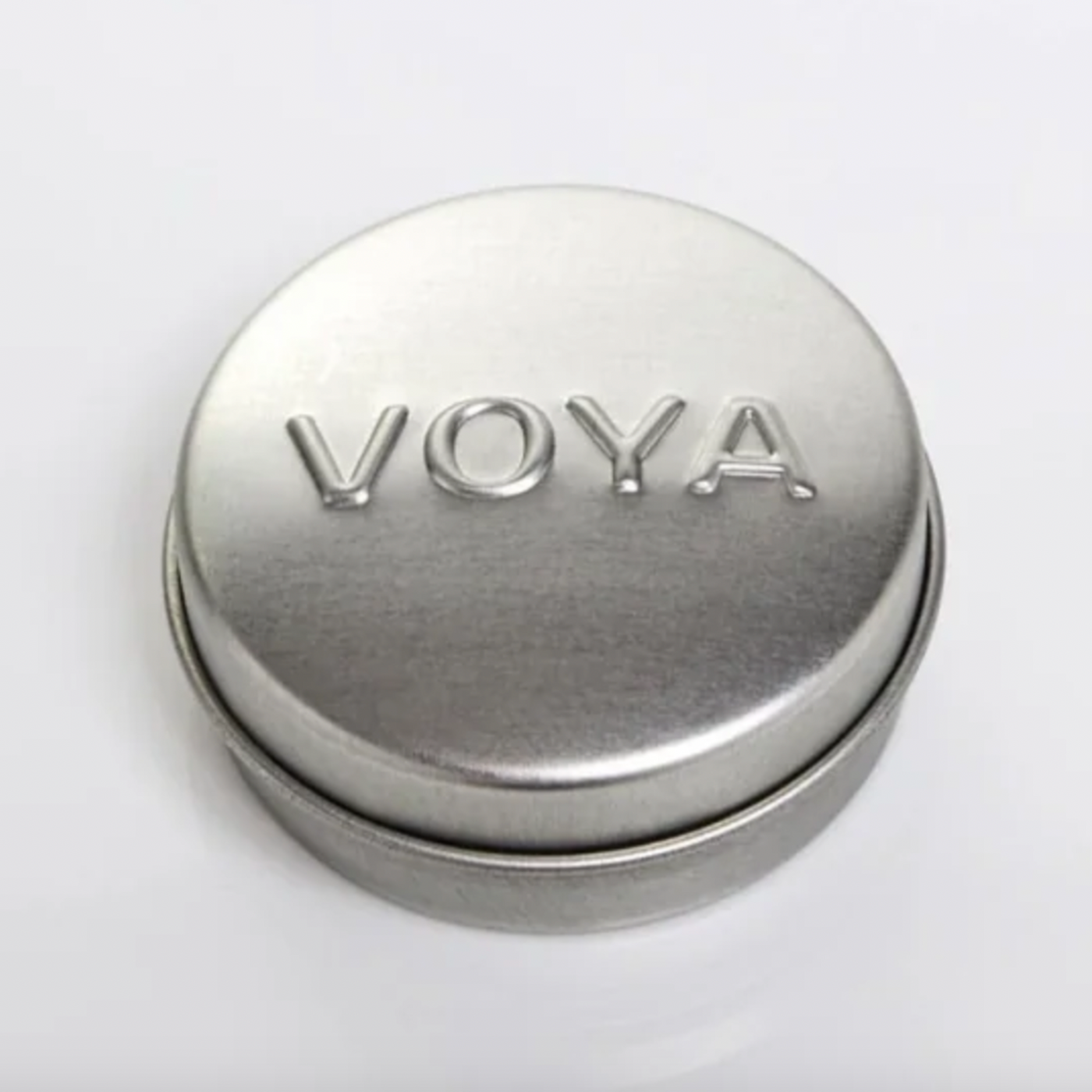 Silver cylindrical Balmelicious container with 'VOYA' branding on a white background