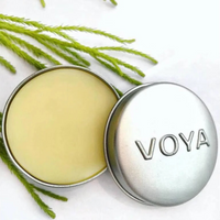 Voya lemon and lime Balmelicious lip balm container with green leaves on a white background