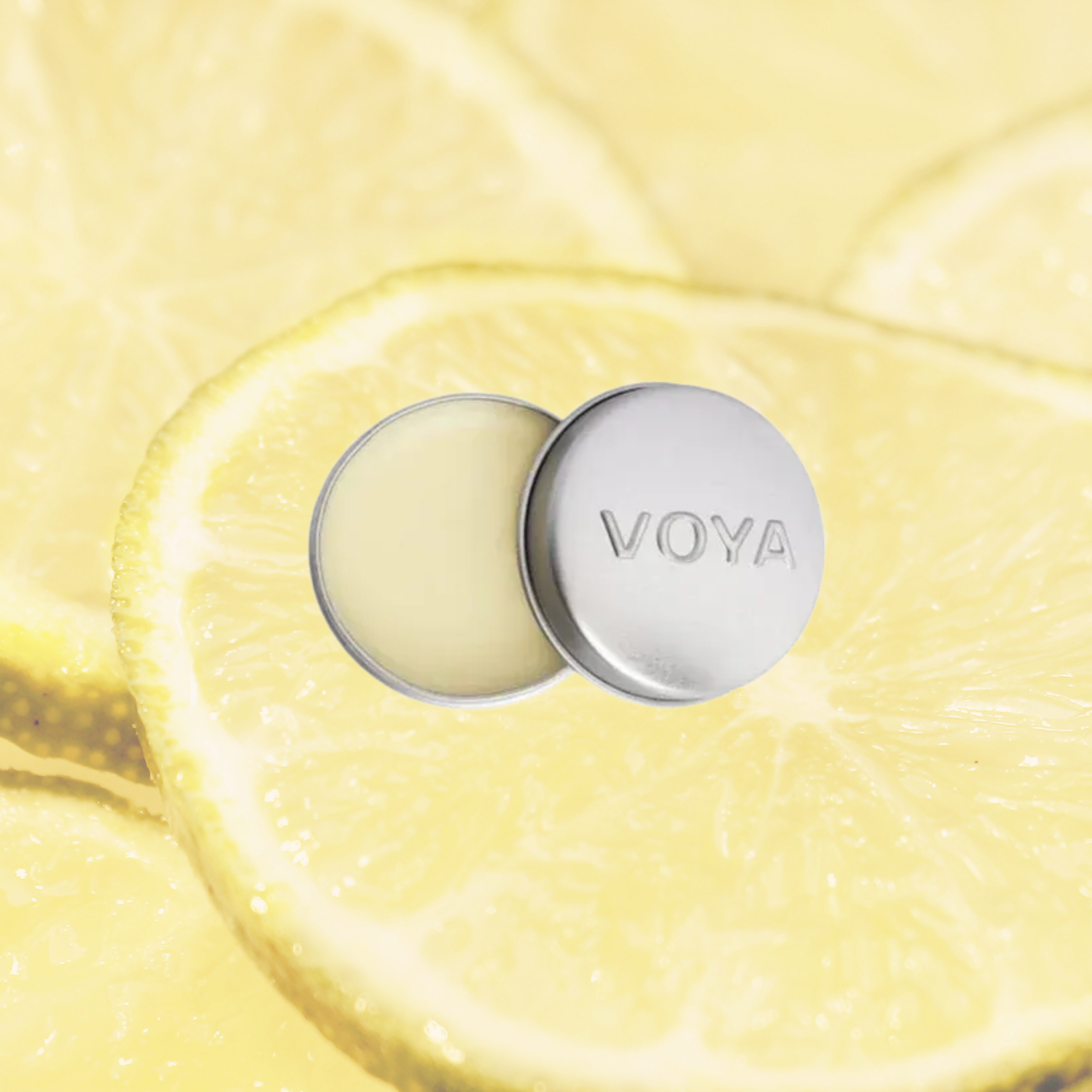 Balmelicious Lemon and Lime with 'VOYA' branding on a yellow textured background