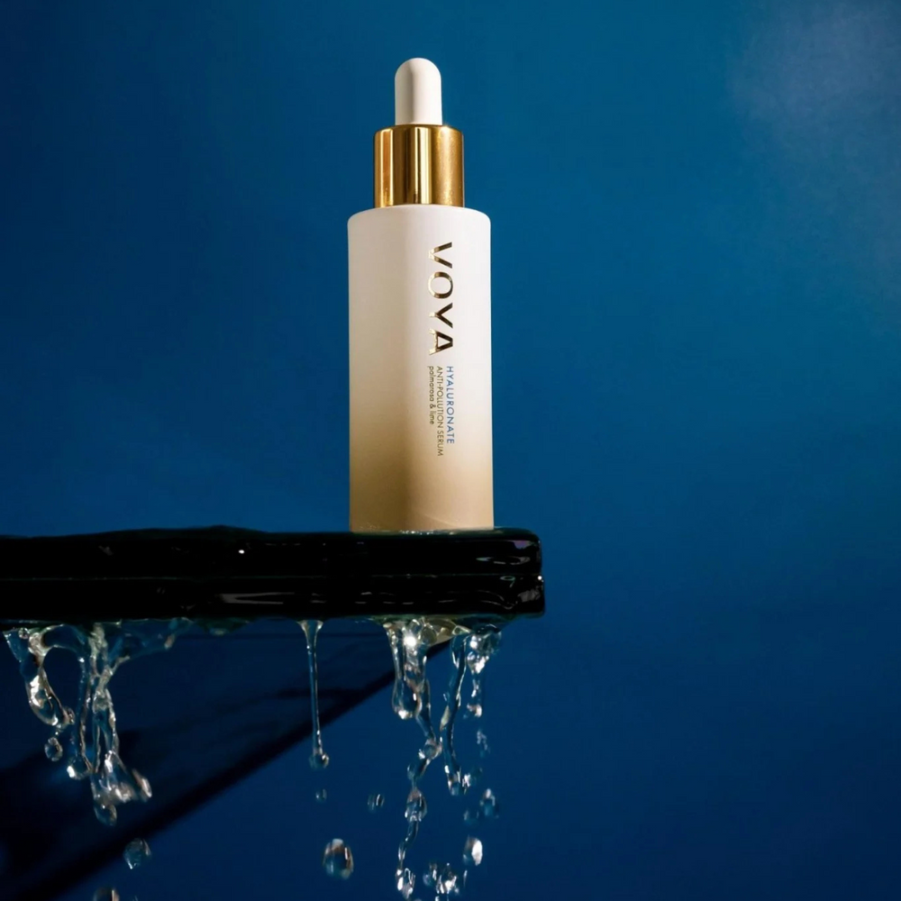 VOYA Hyaluronate Anti-Pollution Serum 30 ml skincare dropper bottle on a reflective surface with a blue background