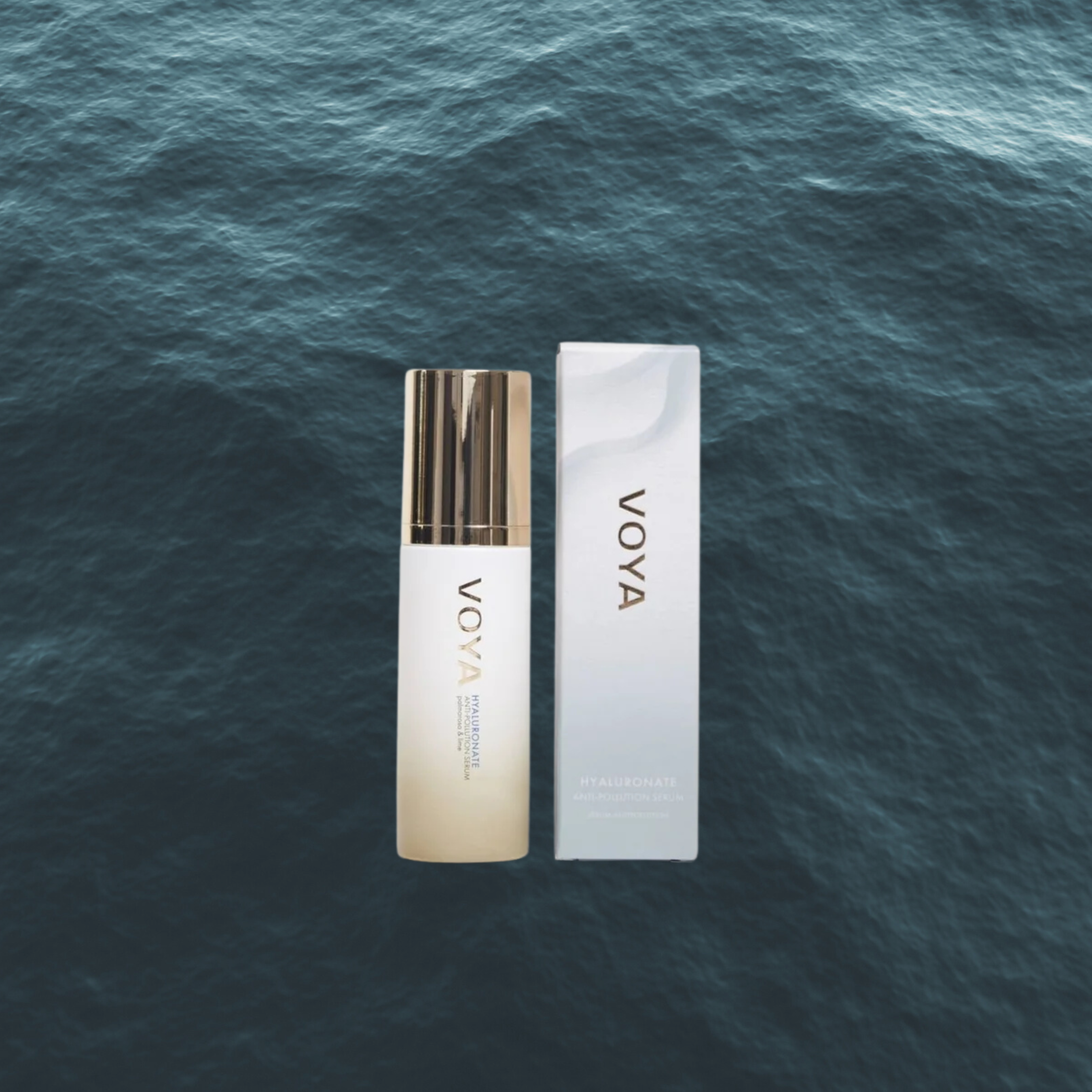 Voya Hyaluronate AntiPollution Serum in glass bottle with gold lid standing next to its box packaging