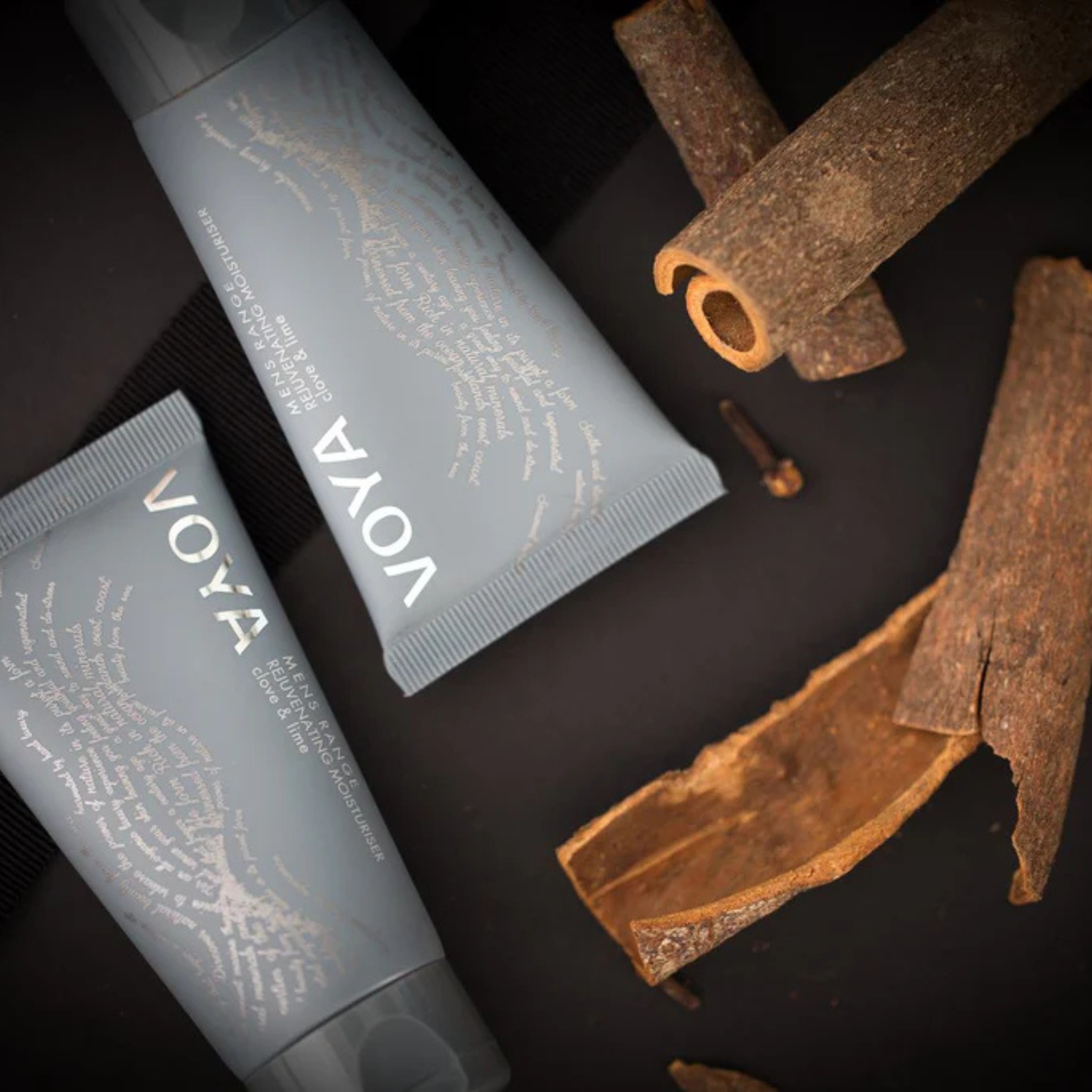 VOYA Men's Range Rejuvenating Moisturiser in blue tube next to cinnamon sticks