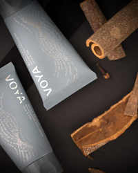 VOYA Men's Range Rejuvenating Moisturiser in blue tube next to cinnamon sticks