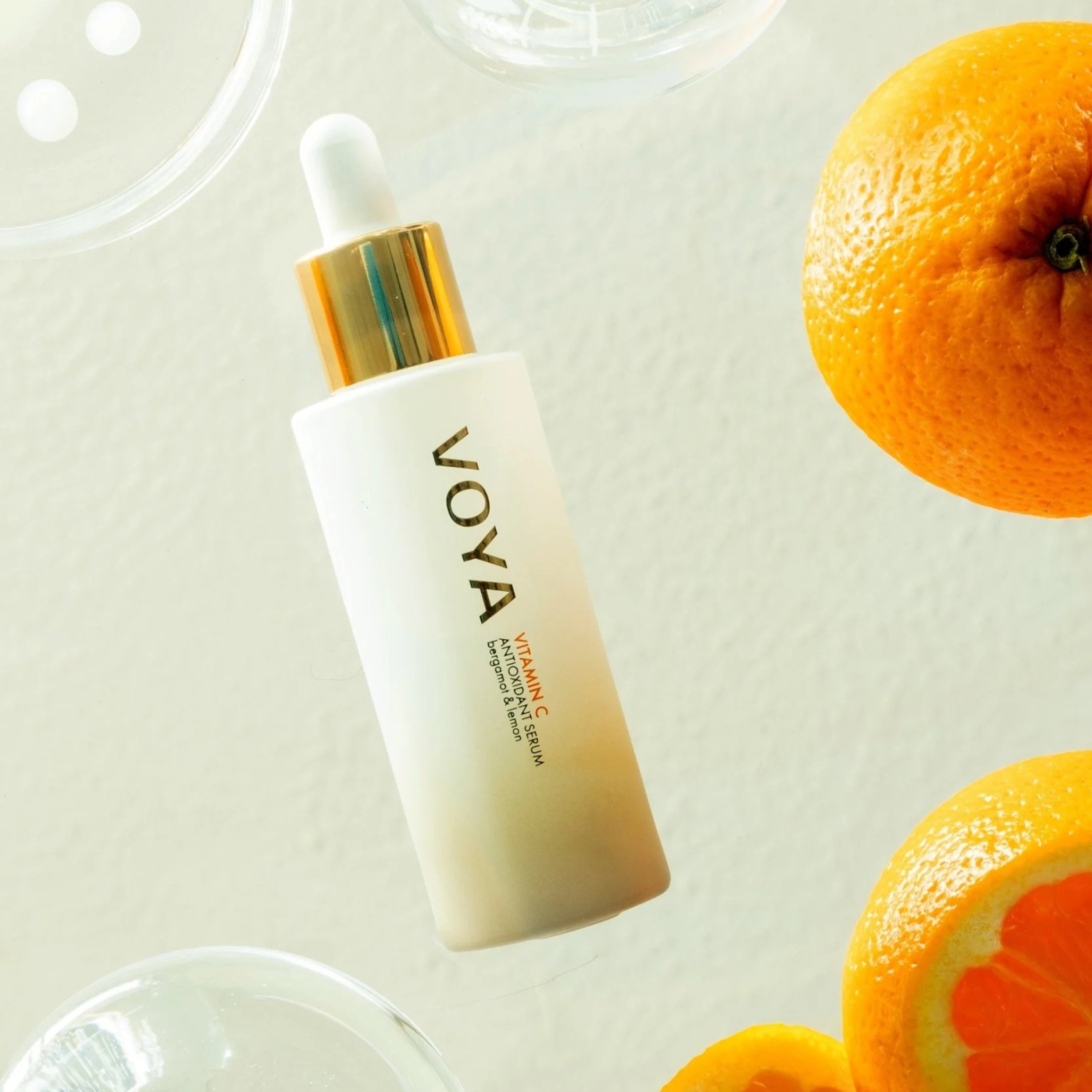 VOYA Vitamin C Antioxidant Serum  skincare dropper bottle with oranges on a light background