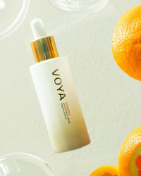 VOYA Vitamin C Antioxidant Serum  skincare dropper bottle with oranges on a light background