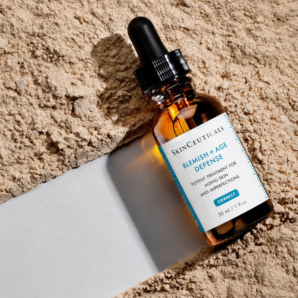 SkinCeuticals Blemish + Age Defense 30ml serum, potent treatment for aging skin and imperfections, dropper bottle on beige powder
