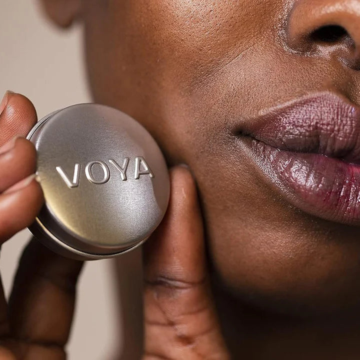 Close-up of a person holding a VOYA lip balm