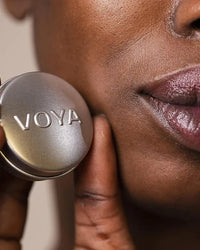 Close-up of a person holding a VOYA lip balm